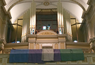 people carrying giant organ pipe